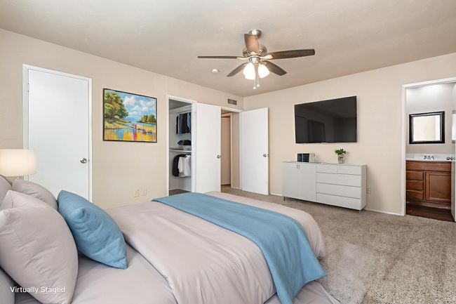 Carpeted bedroom featuring connected bathroom, ceiling fan, and a walk in closet | Image 16