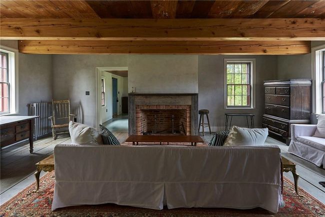 Living room featuring wooden ceiling, a brick fireplace, hardwood / wood-style floors, beamed ceiling, and radiator heating unit | Image 6