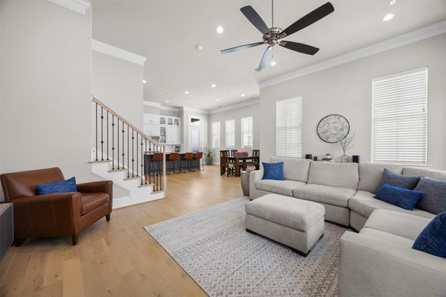 Living room with recessed lighting, ceiling fan, light wood-style floors, ornamental molding, and stairway | Image 5