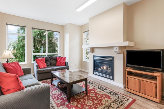 Living area featuring light wood finished floors, baseboards, and a glass covered fireplace | Image 10