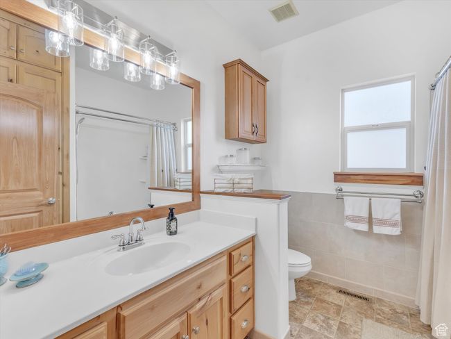 Full bathroom featuring visible vents, toilet, vanity, and a shower with curtain | Image 25