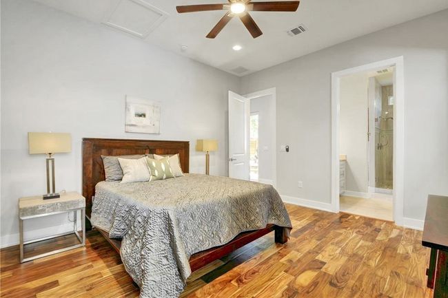 Bedroom featuring baseboards, a ceiling fan, light wood-style flooring, and visible vents | Image 14