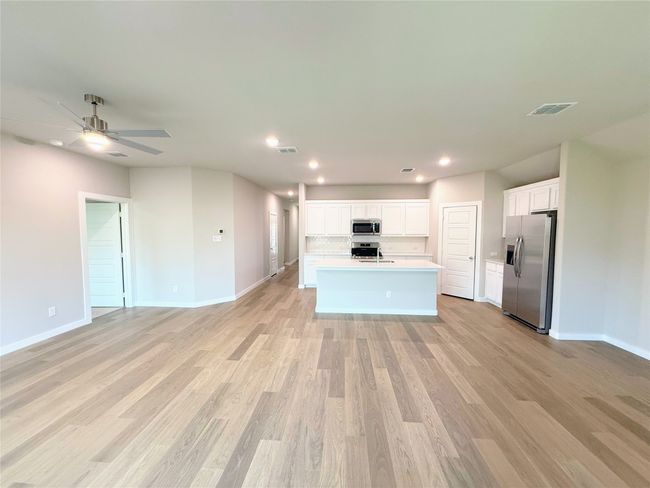Kitchen with open floor plan, appliances with stainless steel finishes, recessed lighting, white cabinetry, and light wood-style flooring | Image 10