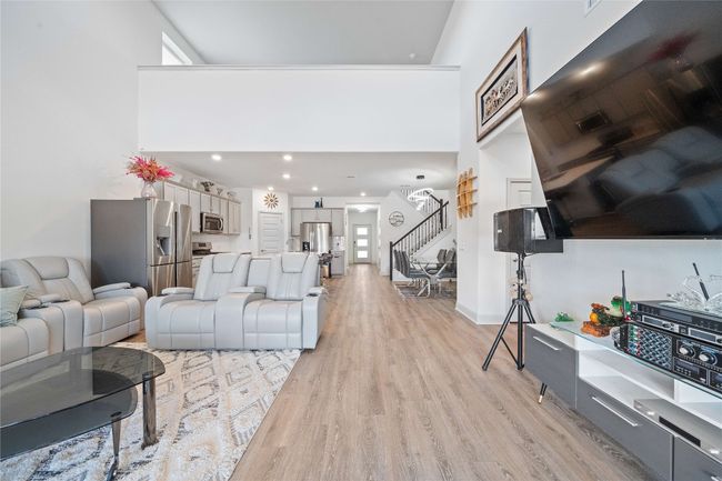 Living area with stairs, light wood-style flooring, and a high ceiling | Image 15