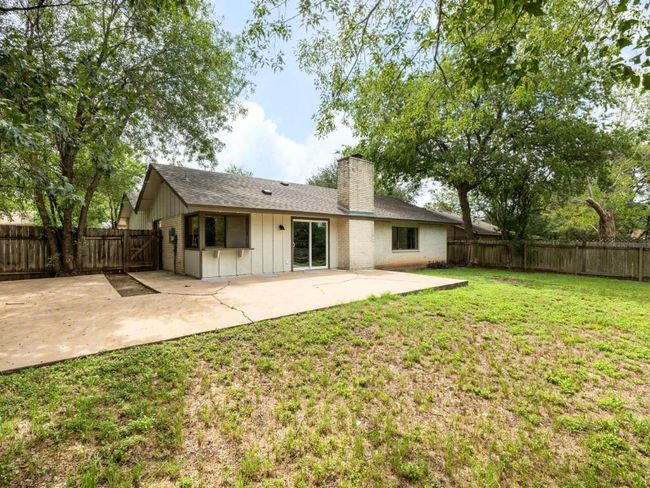 Back of house with a patio, board and batten siding, a chimney, a fenced backyard, and a shingled roof | Image 21