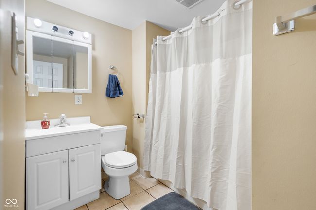 bathroom with toilet, visible vents, curtained shower, tile patterned flooring, and vanity | Image 25