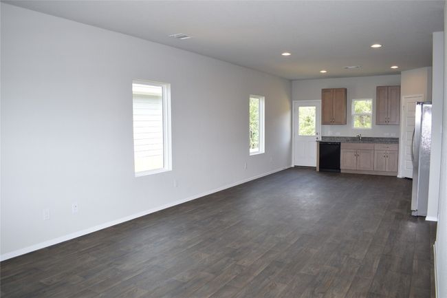 Kitchen with freestanding refrigerator, dark wood-type flooring, recessed lighting, dishwasher, and open floor plan | Image 5