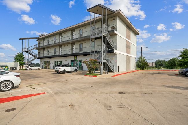 View of building exterior featuring stairway and uncovered parking | Image 14