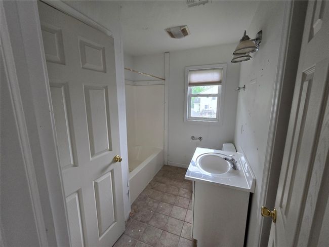 Bathroom with vanity, washtub / shower combination, and baseboards | Image 10