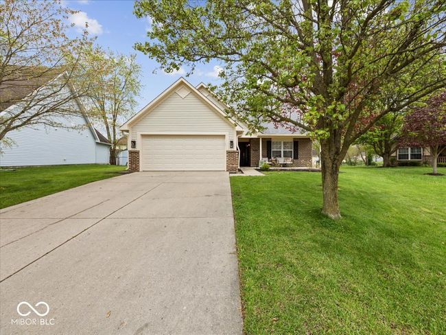 Ranch-style home with long concrete driveway, a nice size front yard, a 2 car attached garage, and brick & vinyl siding | Image 22