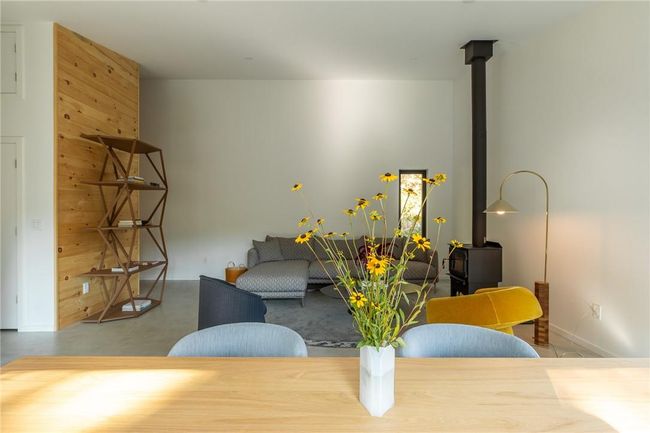 Living room featuring wooden walls, concrete flooring, and a wood stove | Image 7
