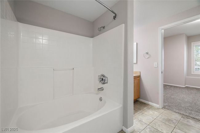 Bathroom featuring tile patterned flooring, bathtub / shower combination, vanity, and baseboards | Image 25