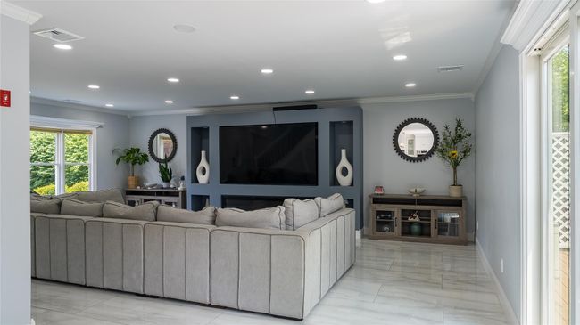 Living area featuring light marble finish floors, ornamental molding, and recessed lighting | Image 8