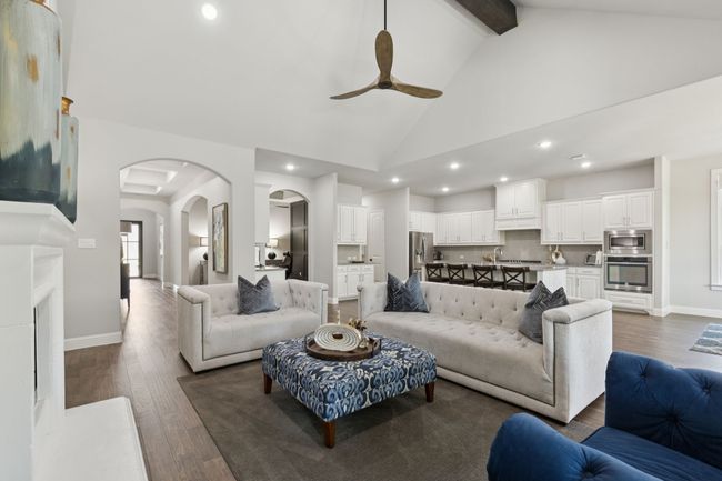 Living area featuring a ceiling fan, recessed lighting, arched walkways, dark wood-style flooring, and high vaulted ceiling | Image 7