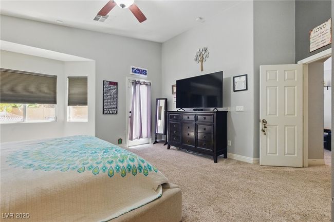 Carpeted bedroom with baseboards, a ceiling fan, visible vents, and a high ceiling | Image 19