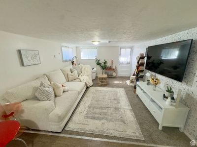 Living room with dark carpet and a textured ceiling | Image 3