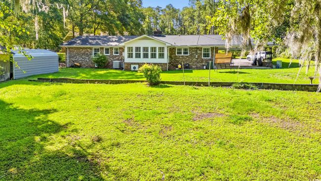 Rear view of property with a shed, a chimney, a lawn, and brick siding | Image 26
