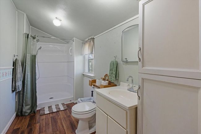 Bathroom with vaulted ceiling, hardwood / wood-style floors, vanity, toilet, and a shower with curtain | Image 23