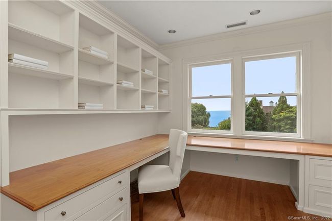 WORK FROM HOME // One of several terrific work from home spaces with inspiring views directly off the primary suite. This home office is adjacent to a large laundry room with water views. | Image 23