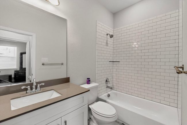 Bathroom featuring vanity and washtub / shower combination | Image 24