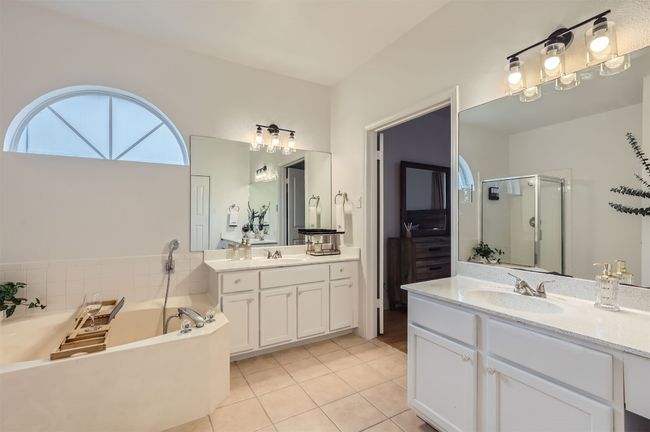 Full bathroom with two vanities, a garden tub, a stall shower, and tile patterned floors | Image 16