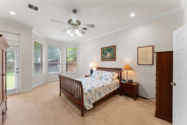 Bedroom featuring light colored carpet, access to outside, multiple windows, ornamental molding, and recessed lighting | Image 16