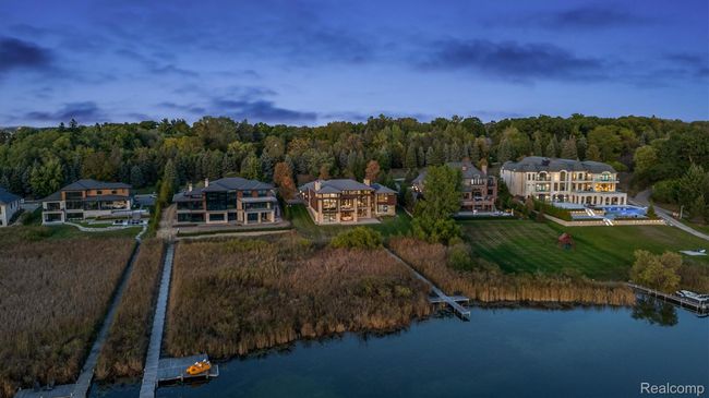 Aerial view of property's location featuring a nearby body of water and a heavily wooded area | Image 34