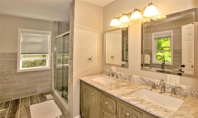 En-suite with hardwood / wood-style flooring, vanity, walk in shower, and tile walls | Image 14