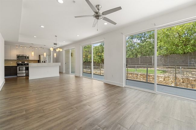 Unfurnished living room with a chandelier, recessed lighting, a ceiling fan, and wood finished floors | Image 7