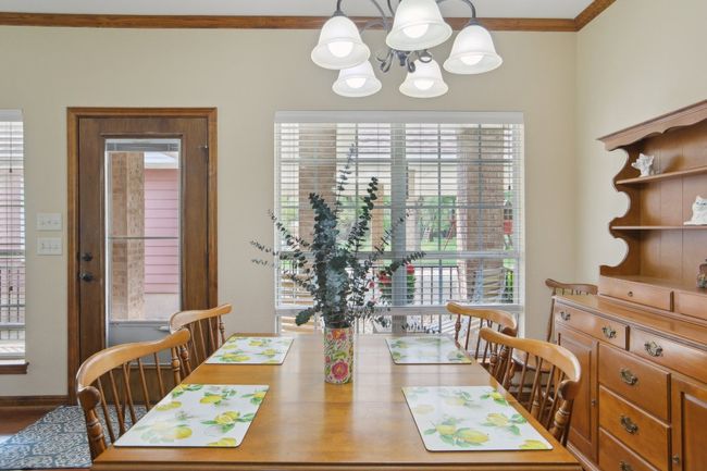 Dining room featuring a healthy amount of sunlight, crown molding, baseboards, and a chandelier | Image 7