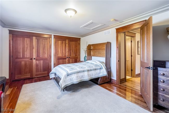 Bedroom with attic access, crown molding, and wood finished floors | Image 37