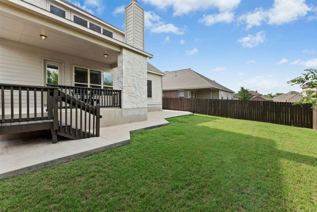 Gorgeous outdoor fireplace on raised cement deck. Private yard. Extended cement patio around back and sides of home. Great space for entertaining! | Image 30