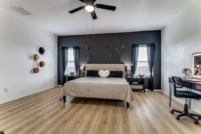 Bedroom with wood finished floors, a ceiling fan, and an accent wall | Image 25
