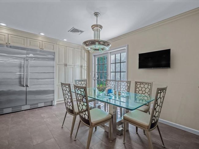 Dining area featuring crown molding, a chandelier, baseboards, and recessed lighting | Image 10