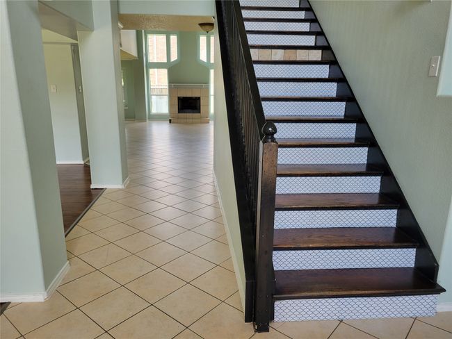 Staircase with tile patterned flooring and a tile fireplace | Image 11