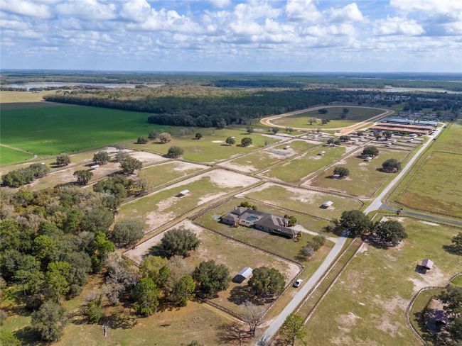Overhead view of property with main house in forefront and farm facility in back. | Image 5