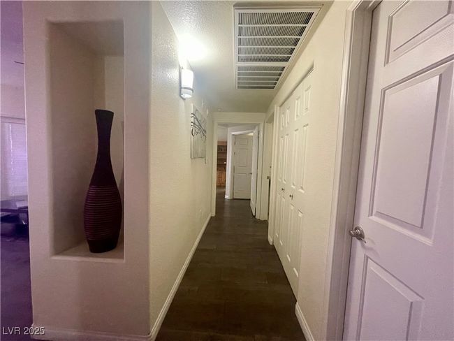 Corridor featuring visible vents, baseboards, and dark wood finished floors | Image 37