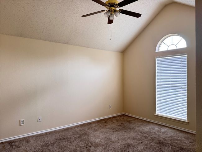 Spare room featuring carpet, ceiling fan, lofted ceiling, and baseboards | Image 12