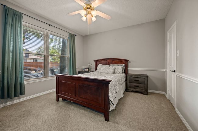 Bedroom with light carpet, a textured ceiling, and ceiling fan | Image 18