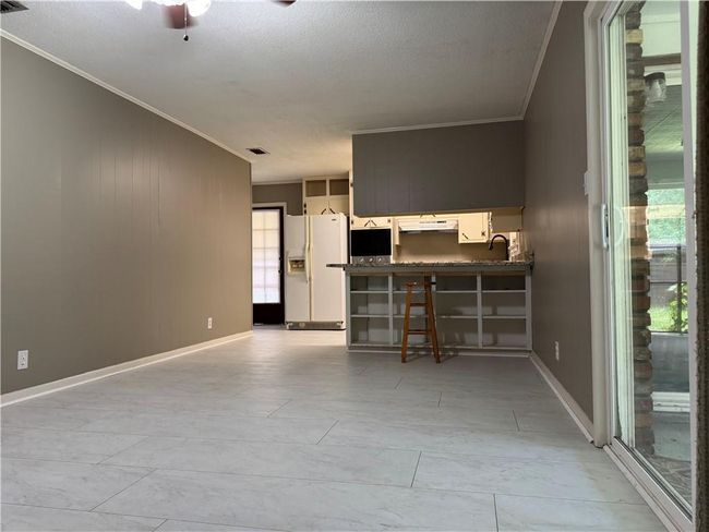 Unfurnished living room with ornamental molding, a textured ceiling, and a ceiling fan | Image 7