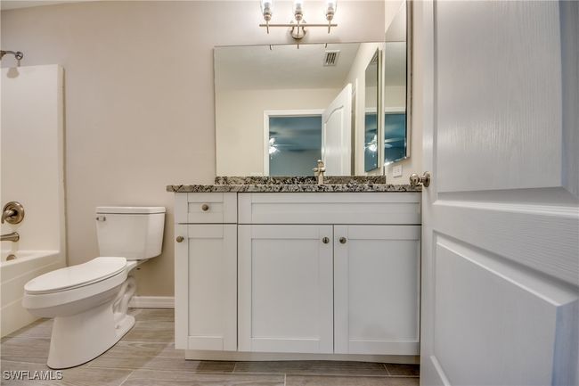 Full bathroom featuring baseboards, visible vents, toilet, vanity, and washtub / shower combination | Image 33
