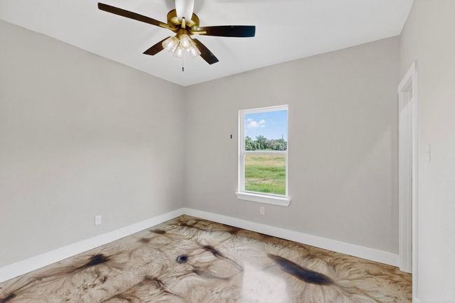 Spare room with a ceiling fan and baseboards | Image 36