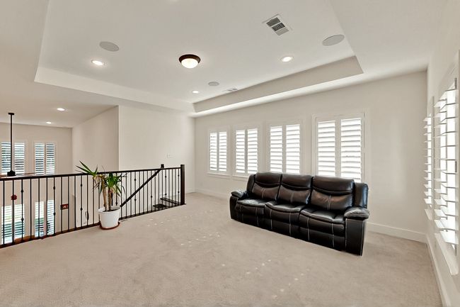 Living area featuring carpet flooring, a raised ceiling, healthy amount of natural light, baseboards, and recessed lighting | Image 15