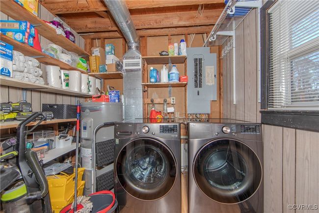 Clothes washing area with electric panel, washing machine and dryer, electric water heater, and wooden walls | Image 9