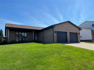 View of front of house with a front lawn and a garage | Image 1