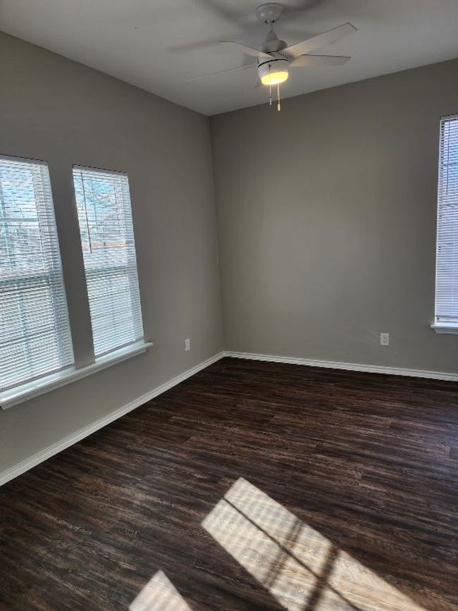 Spare room featuring baseboards, wood finished floors, and ceiling fan | Image 7