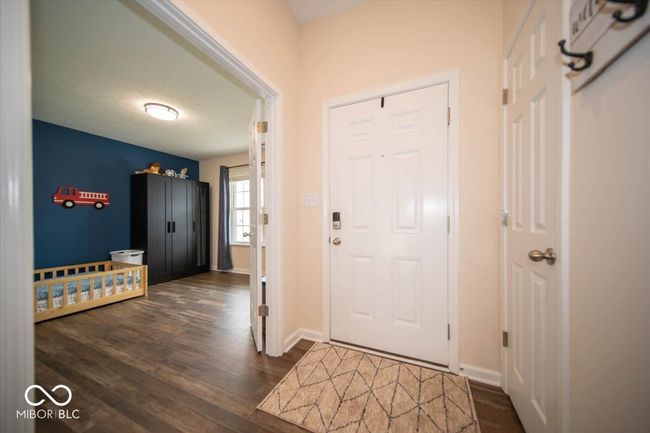 foyer entrance featuring dark vinyl flooring with wood appearance and baseboards | Image 7
