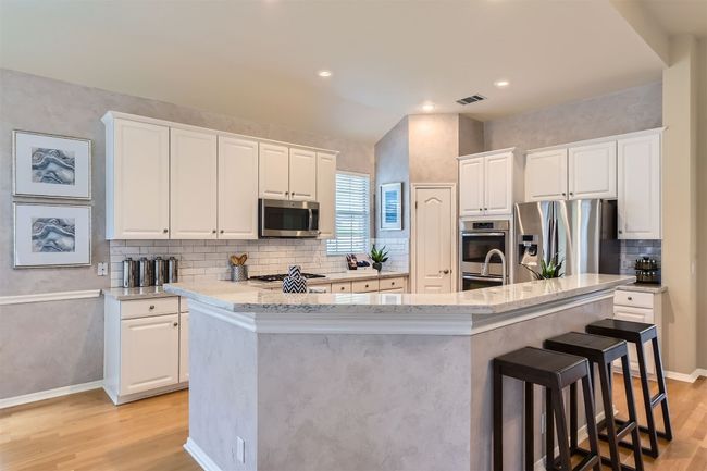 Kitchen with updated white cabinetry, with hardware, quartz counter tops, stainless steel appliances, marble subway style backsplash | Image 10