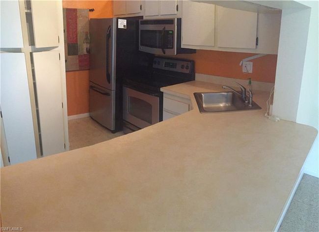 Kitchen with stainless steel appliances, light countertops, and white cabinets | Image 4