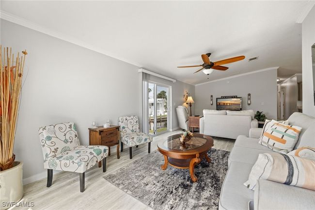 Living room featuring visible vents, ceiling fan, baseboards, ornamental molding, and light wood finished floors | Image 20
